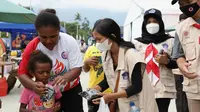 Relawan protokol kesehatan Satgas Penanganan COVID-19 memberikan masker kain kepada warga di sekitar Stadion Barnaban Yumeo, Papua, Senin (27/9/2021). (Dok BNPB)