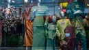 Seorang wanita mengenakan masker sebagai tindakan pencegahan Covid-19 melihat ponselnya di depan sebuah toko yang menjual pakaian budaya Malaysia yang disebut Baju Melayu dan Baju Kurung menjelang Idul Fitri yang menandai berakhirnya bulan suci Ramadan di Kuala Lumpur (13/5/2020). (AFP/Mohd Rasfan)
