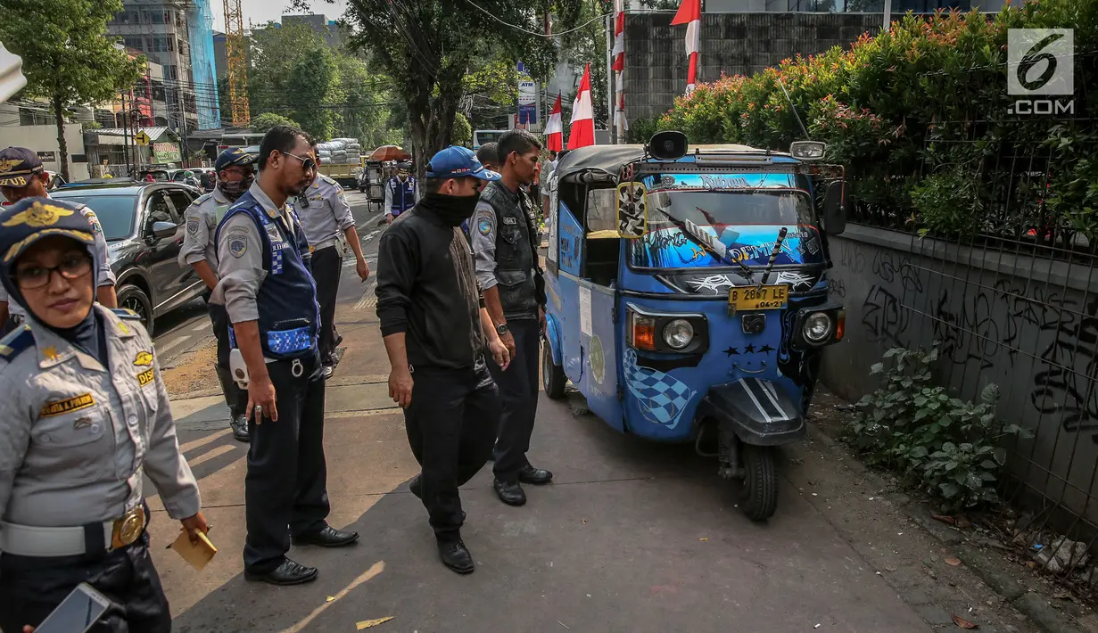 Petugas Dinas Perhubungan (Dishub) merazia bajaj yang parkir liar di atas trotoar kawasan KH Wahid Hasyim, Jakarta, Selasa (1/8). Penertiban dalam rangka Bulan Patuh Trotoar itu untuk mengembalikan fungsi trotoar. (Liputan6.com/Faizal Fanani)