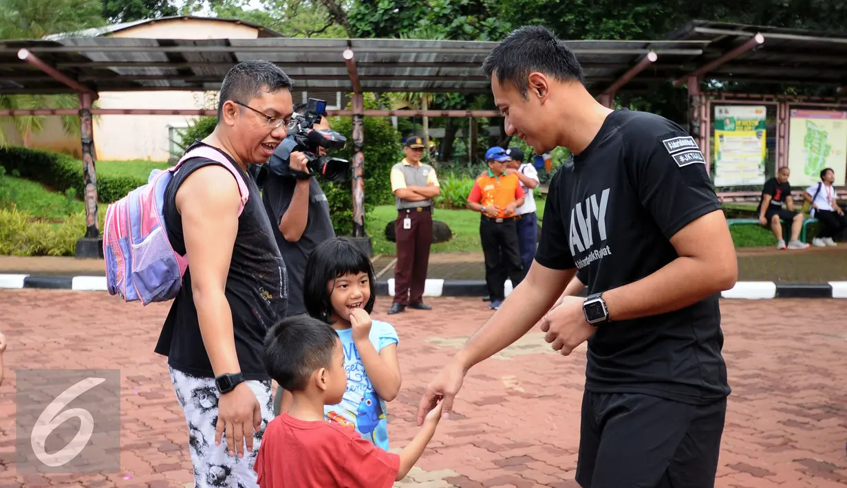 Bakal calon gubernur DKI Jakarta, Agus Harimurti Yudhoyono (kanan) menyalami anak-anak saat berolahraga di Area Kebun Binatang Ragunan Jakarta, Minggu (9/10). Selain olahraga, AHY juga melakukan  sosialisasi. (Liputan6.com/Helmi Fithriansyah)