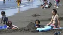 Orang-orang menikmati Pantai Shonan untuk menyejukkan diri dari teriknya musim panas di Fujisawa, dekat Tokyo, Selasa, (11/8/2020). (AP / Koji Sasahara)