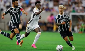 Pemain Real Madrid, Vinicius Jr (tengah), mengontrol bola dibayangi dua pemain MU, Bruno Fernandes (kiri) dan Lisandro Martinez, dalam pertandingan pramusim Soccer Champions Tour 2023 yang berlangsung di NRG Stadium, Houston, Kamis (27/7/23). (AFP/Getty Images/Tim Warner)