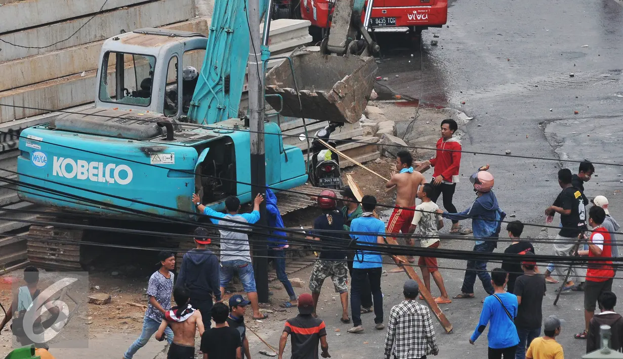 Sebuah alat berat di rusak massa saat kericuhan penggusuran Kampung Pulo, Jakarta, Kamis (20/8/2015). Penggusuran permukiman Kampung Pulo yang dilakukan oleh 2.200 personel gabungan untuk normalisasi Sungai Ciliwung. (Liputan6.com/Herman Zakharia)