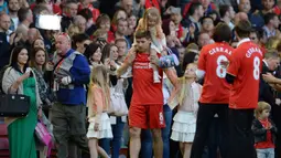 Gelandang Liverpool, Steven Gerrard ditemani putri-putrinya memasuki lapangan usai menjalani partai kandang terakhirnya melawan Crystal Palace di Anfield, 16 Mei 2015. Liverpool kalah 1-3. (AFP/Oli Scarff)