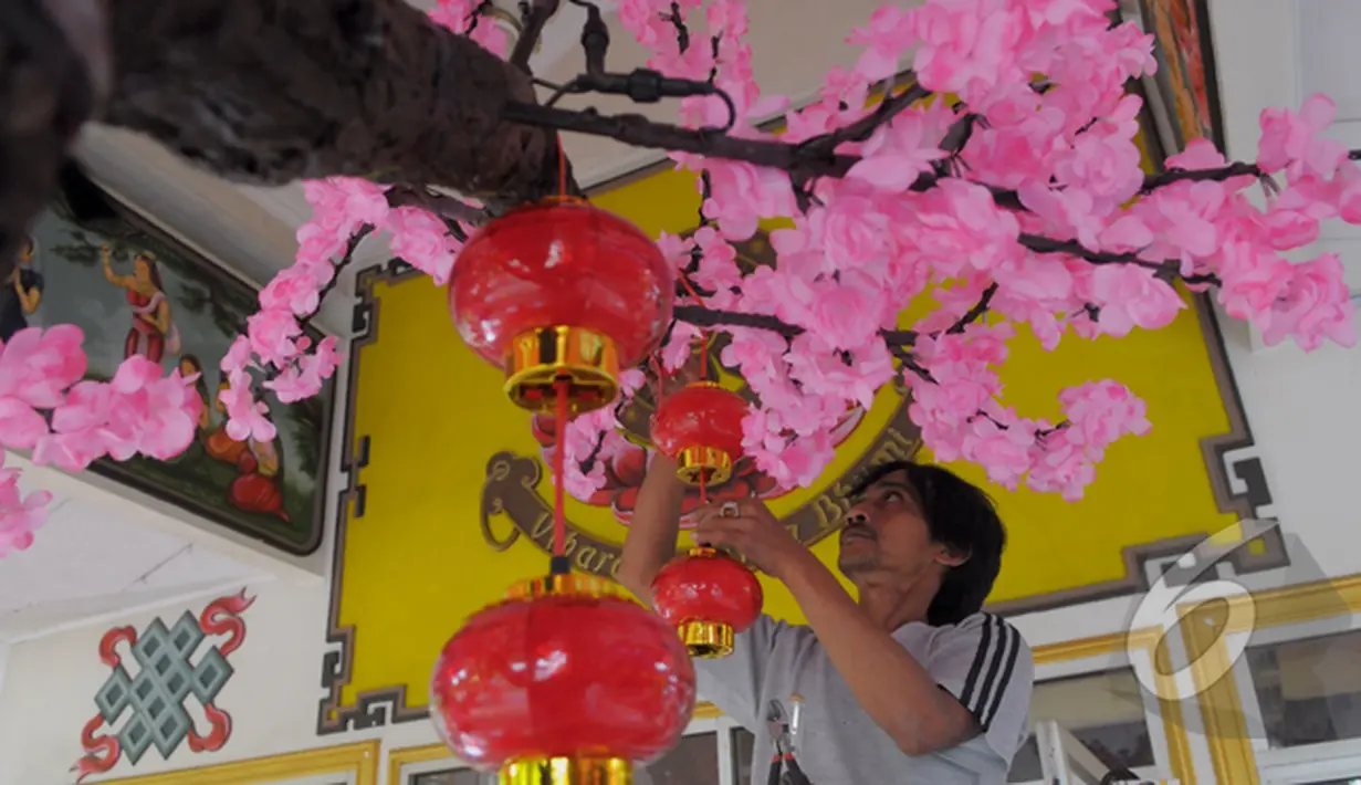 Petugas mempercantik dengan memasang hiasan - hiasan berupa lampion di Vihara Amurva Bhumi, Jakarta, Sabtu (14/02/2015). Menjelang imlek sejumlah kelenteng mulai dipercantik (Liputan6.com/Andrian M Tunay)