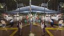 Orang-orang yang terlihat dalam refleksi berjalan melintasi persimpangan di tengah hujan di Tokyo pada hari Kamis (8/10/2020). (AP Photo/Hiro Komae)
