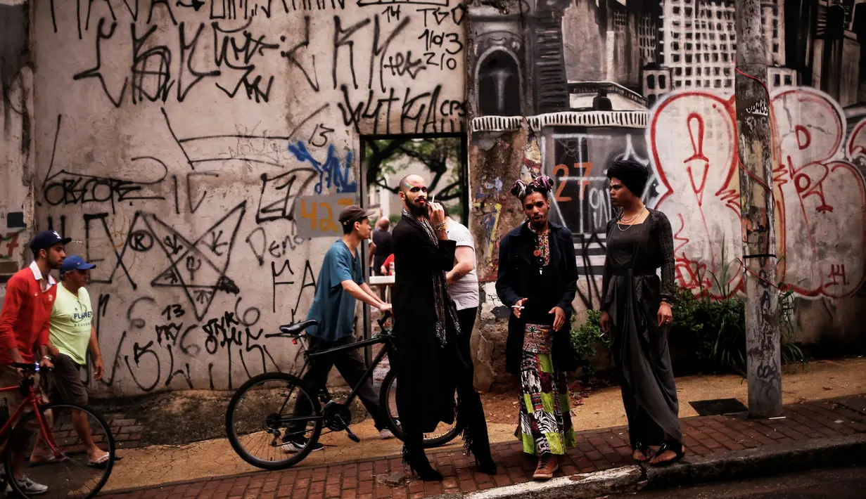  Anggota LGBT, Fernanda, Rodrigo dan Teflon berbincang di depan pintu gedung tua di Sao Paulo, Brasil (26/11). Mereka adalah anggota kaum LGBT yang telah diundang untuk bergabung bersama kelompok sosial Gerakan Tanpa Atap. (Reuters/Nacho Doce)