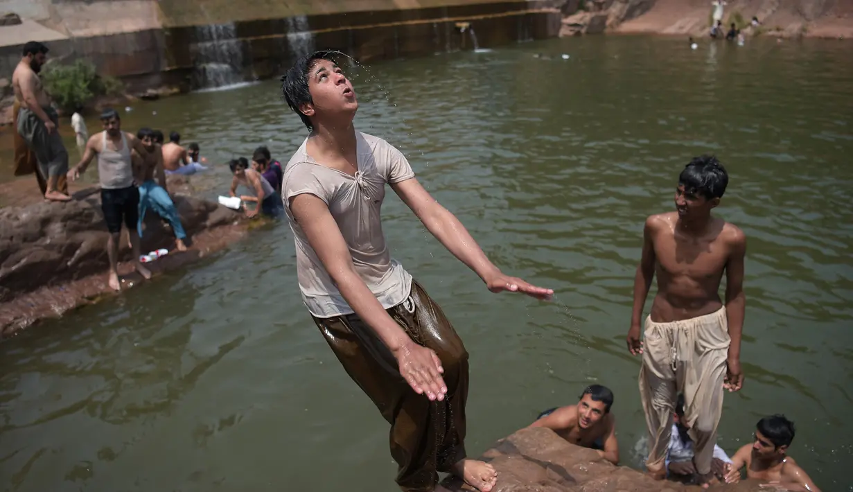 Mandi di sungai menjadi pilihan warga Pakistan untuk mendinginkan tubuh saat suhu di siang hari mencapai 43 derajat celcius, Islamabad, Pakistan, Senin (5/6). (AFP PHOTO / AAMIR QURESHI)