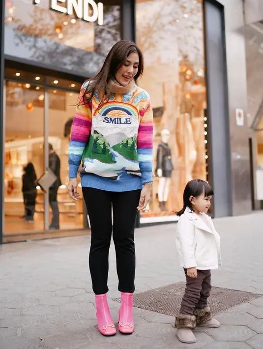 Keluarga Syahnas Sadiqah diketahui tengah berada di Swiss untuk merayakan tahun baru. Berpose di jalanan bersama putri kecilnya, Syahnas tampil stylish dalam balutan  sweater warna-warni, pants, dan sepatu boots warna pink (Instagram/syahnazs)
