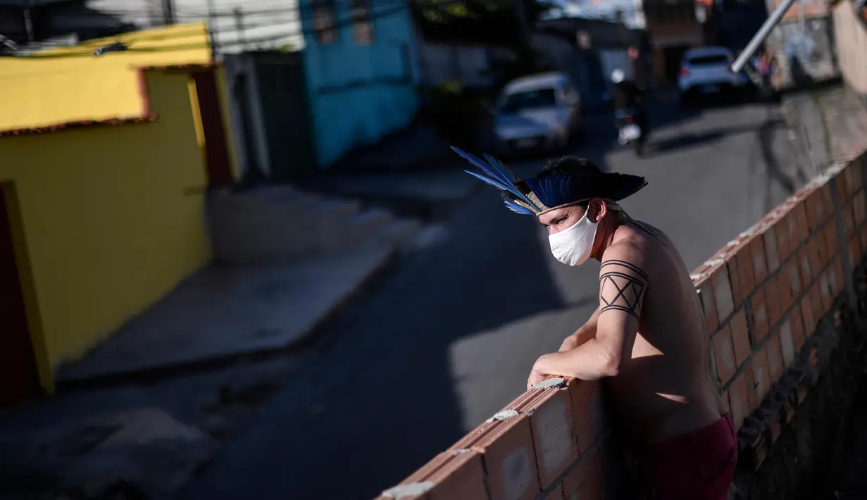 Seorang anggota kelompok etnis Pataxo Hahahae mengenakan masker di Vila Vitoria favela di pinggiran Belo Horizonte, negara bagian Minas Gerais, Brasil, pada 8 Juli 2020 di tengah pandemi coronavirus novel COVID-19.  (AFP/Douglas Magno)
