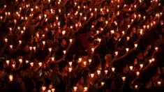 Umat Kristen memegang lilin saat ibadah malam Natal di Gereja Bethany, Surabaya, Jawa Timur, Minggu (24/12/2023). Pelaksanaan ibadah malam Natal berjalan aman dan lancar. (Juni KRISWANTO/AFP)