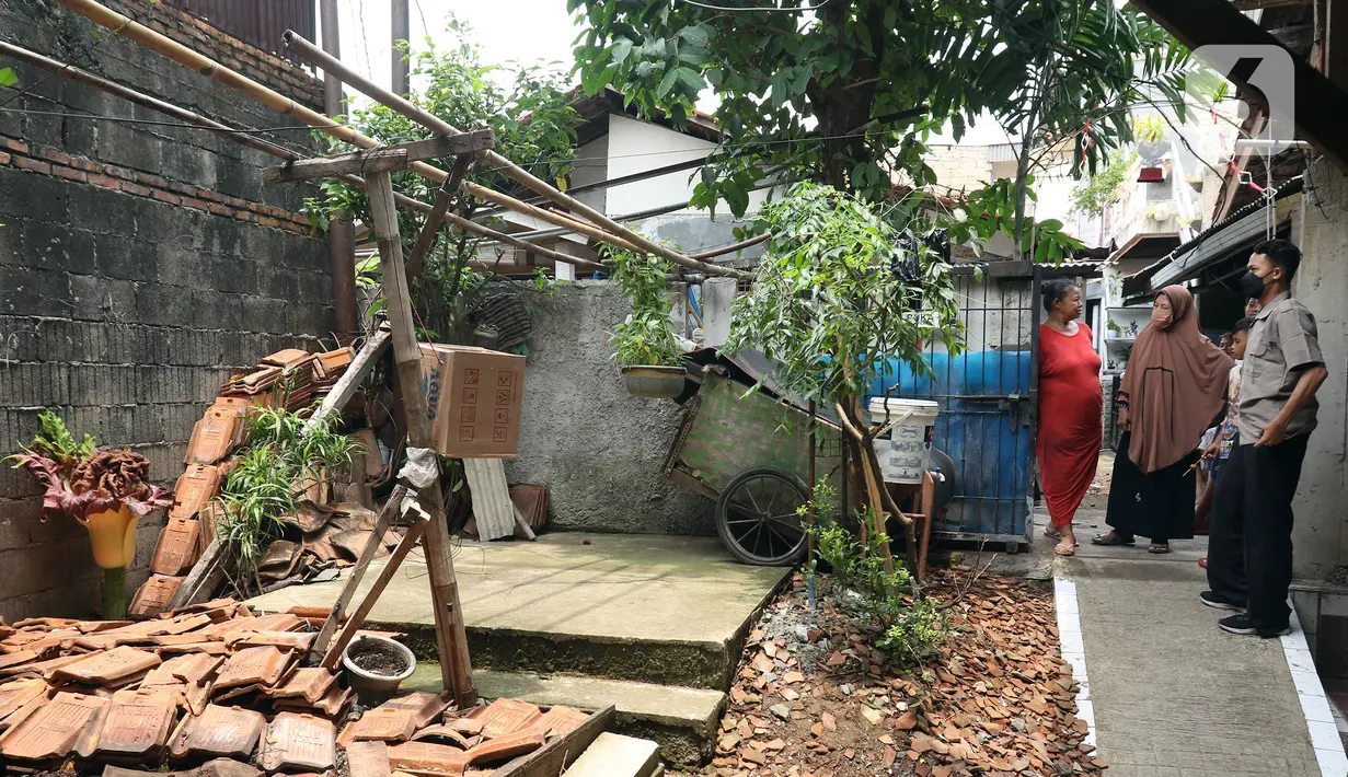 Sejumlah warga melihat tanaman yang diduga jenis bunga bangkai di kawasan Cipete, Jakarta, Rabu (13/10/2021). Bunga yang tumbuh di pekarangan rumah warga itu mengeluarkan bau menyengat dan menjadi pusat perhatian warga sekitar. (Liputan6.com/Hermann Zakharia)