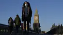 Orang-orang berjalan di atas Jembatan Westminster di London, pada Kamis (20/1/2022). Pemerintah Inggris mengakhiri pembatasan COVID-19, termasuk mandat masker, bekerja dari rumah dan paspor vaksin mulai Kamis. (AP Photo/Kirsty Wigglesworth)
