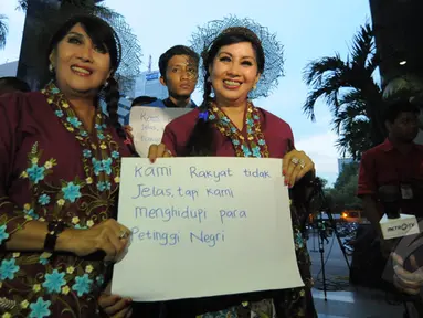 Sepasang guru kembar menyambangi gedung KPK, Jakarta, Senin (26/1/2015). Kunjungan mereka sebagai bentuk dukungan kepada KPK. (Liputan6.com/Herman Zakharia)