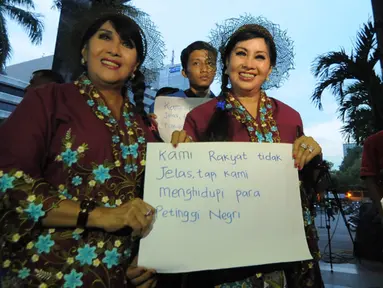 Sepasang guru kembar menyambangi gedung KPK, Jakarta, Senin (26/1/2015). Kunjungan mereka sebagai bentuk dukungan kepada KPK. (Liputan6.com/Herman Zakharia)