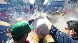 Koki saat menuangkan kacang lentil rebus di panci raksasa untuk memecahkan rekor dunia Guinness Record dalam acara Prado Rural di Montevideo, Uruguay, Minggu (13/9/2015). Kacang tersebut cukup untuk memberi makan 10.000 orang. (AFP PHOTO/Miguel Rojo)