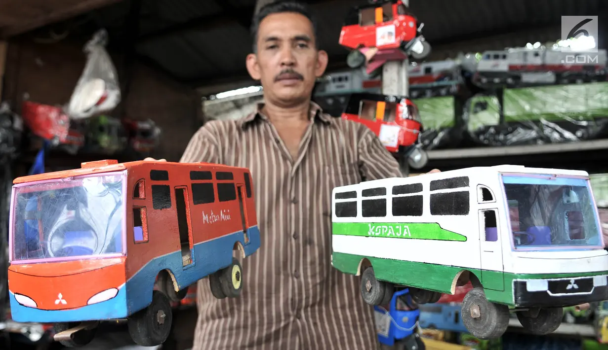 Sukma menunjukkan mainan kayu yang dijualnya di kawasan Kalibata, Jakarta, Rabu (17/10). Sukma menjual jenis mainan tradisional seperti miniatur bus, kereta, bajaj, kuda-kudaan, dan hiasan rumah. (Merdeka.com/Iqbal S. Nugroho)