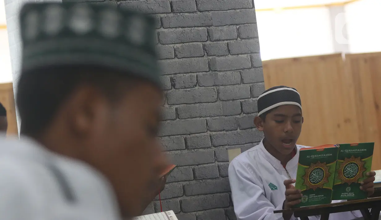 Seorang santri membaca Al-Quran di Pesantren Nuu Waar Al Fatih Kaffah Nusantara (AFKN) di Setu, Kabupaten Bekasi, Jawa Barat, Sabtu (1/5/2021). Kegiatan Khatam Al-Quran tersebut dilakukan rutin setiap bulan Ramadhan oleh 750 santri dan santriwati. (Liputan6.com/Herman Zakharia)