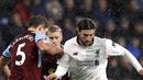 Pemain Burnley, James Tarkowski (kiri) menghalau bola dari kaki pemain Liverpool, Adam Lallana pada lanjutan Premier League di Turf Moor, Burnley, (1/1/2018). Liverpool menang 2-1 atas Burnley. (Martin Rickett/PA via AP)
