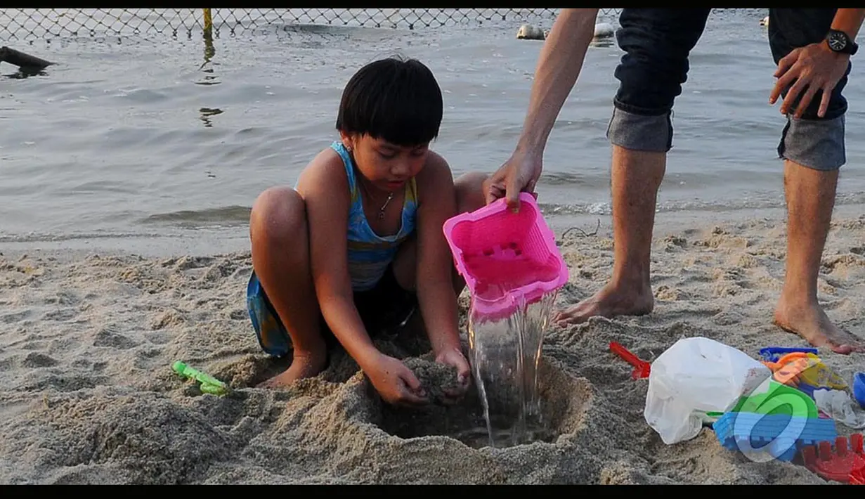 Seorang bocah sedang bermain pasir saat Lebaran di pantai Ancol, Jakarta, Senin (28/7/2014) (Liputan6.com/Andrian M Tunay)