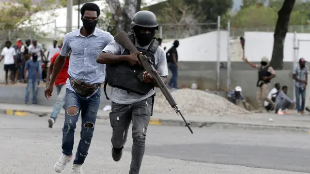 Petugas polisi yang berlari ke arah bentrokan bersenjata dengan tentara selama protes di Port-au-Prince, Haiti, Minggu, 23 Februari 2020.