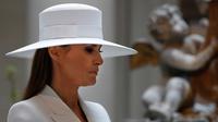 Istri Presiden AS Donald Trump, Melania Trump mengenakan topi saat mendampingi istri Presiden Prancis Brigitte Macron di National Gallery of Art di Washington (24/4). (AP/Jacquelyn Martin)