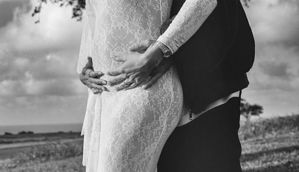 Sambil memegang baby bump, Hailey Bieber terlihat romantis dalam dekapan Justin Bieber. Hailey Baldwin menggunakan long dress brokat yang terlihat jelas menonjolkan bagian perutnya. (Liputan6.com/IG/@justinbieber)