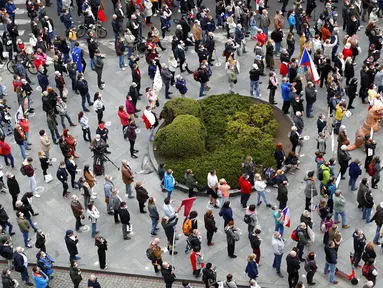 Warga berusaha jaga jarak saat berdemonstrasi di Praha, Republik Ceko, Kamis (29/4/2021). Ribuan warga berunjuk rasa menentang Presiden Milos Zeman dan menuduhnya melakukan pengkhianatan atas sikap pro Rusia pada dugaan partisipasi mata-mata Rusia dalam ledakan di Ceko. (AP Photo/Petr David Josek)