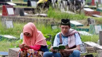 Warga berdoa saat berziarah di TPU Karet Pasar Baru Barat, Jakarta, Sabtu (16/6). Ziarah kubur atau "nyekar" pada hari raya lebaran merupakan salah satu tradisi umat muslim untuk mendoakan sanak keluarga yang meninggal dunia. (Liputan6.com/Arya Manggala)