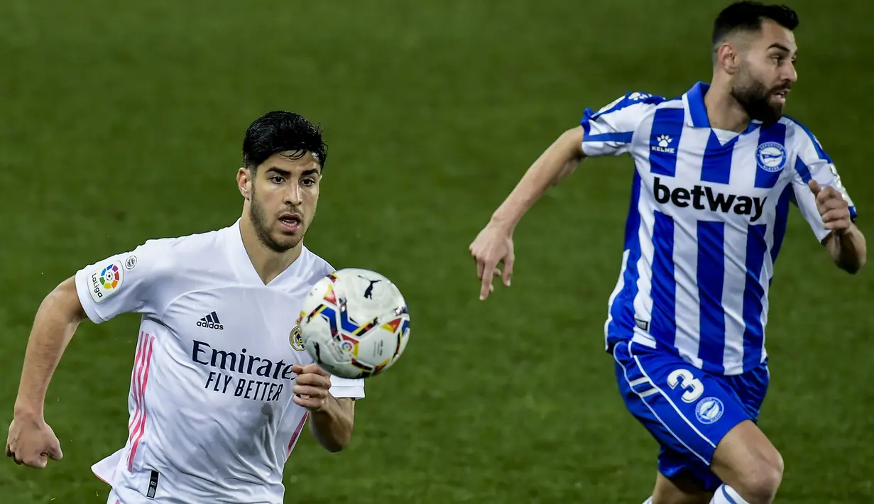 Gelandang Real Madrid, Marco Asensio mengejar bola saat bertanding melawan Deportivo Alaves pada pertandingan lanjutan La Liga Spanyol di stadion Mendizorroza di Vitoria. Minggu (24/1/2021). Madrid tertinggal 4 poin dari Atletico Madrid di puncak klasemen. (AP Photo/ Alvaro Barrientos)