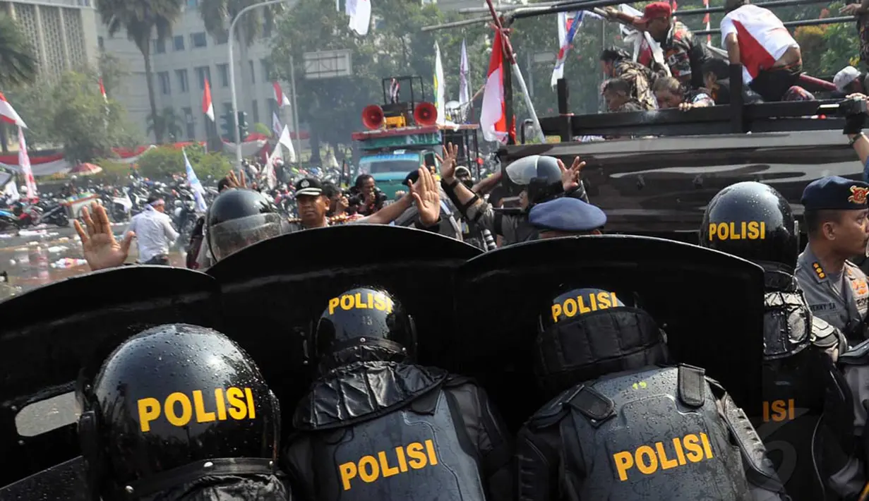 Aparat Kepolisian terus memukul mundur pendukung Prabowo yang telah kocar-kacir akibat gas air mata dan semprotan air, Jakarta, Kamis (21/8/2014) (Liputan6.com/Miftahul Hayat) 