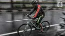 Pesepeda saat menerobos hujan di Jalan Pramuka, Jakarta, Kamis (18/2/2021). Badan Meteorologi Klimatologi dan Geofisika (BMKG) mengimbau pengguna jalan agar berhati-hati saat berkendara karena hujan disertai angin kencang diprediksi terus berlanjut hingga akhir Februari (merdeka.com/Iqbal S Nugroho)