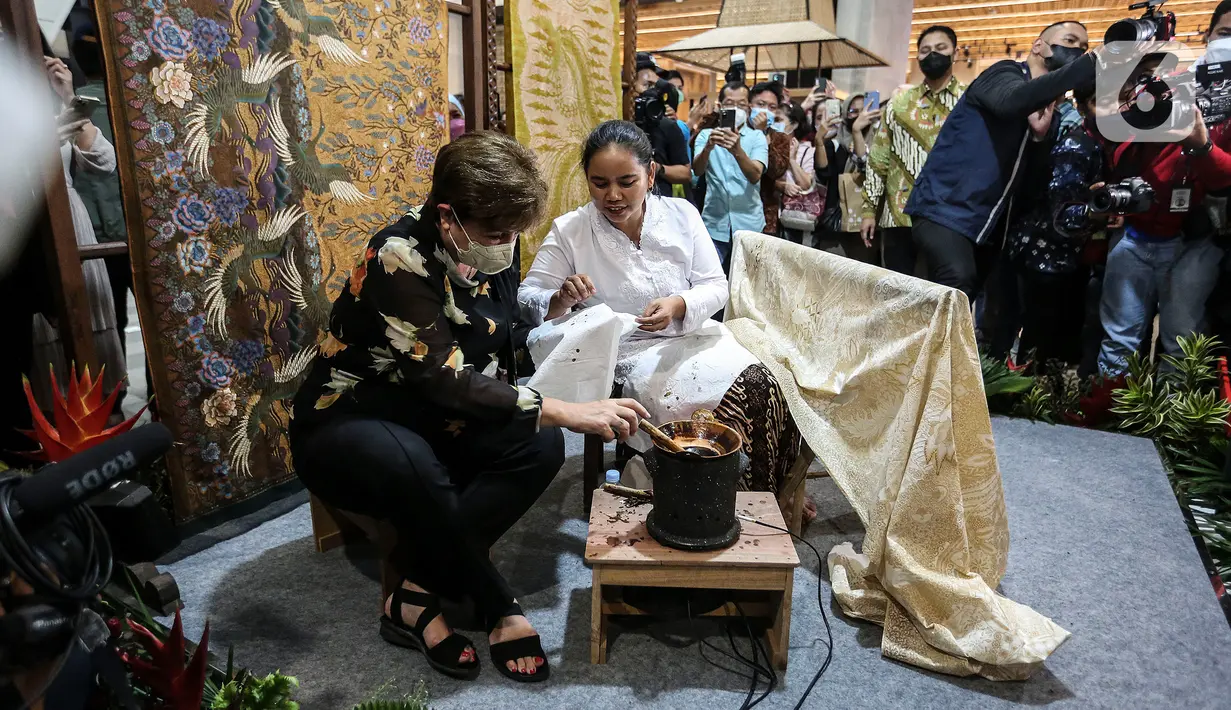 Direktur Pelaksana Dana Moneter Internasional (IMF) Kristalina Georgieva mencoba membatik saat mengunjungi Gedung Sarinah, Jakarta, Minggu (17/7/2022). (Liputan6.com/Johan Tallo)