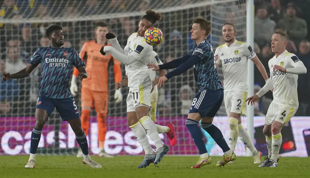 Penyerang Arsenal Martin Odegaard berebut bola dengan penyerang Leeds United Tyler Roberts pada pekan ke-18 Liga Inggris di Stadion Ellan Road, Leeds, Minggu (19/12/2021) dini hari WIB. Arsenal menang 4-1 di kandang Leeds United. (AP Photo/Jon Super)