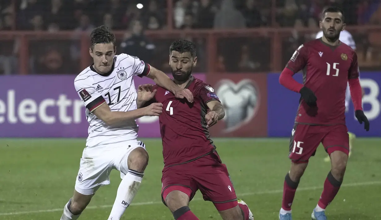 Pada menit ke-43 Jerman memperoleh hadiah penalti. Lewat rekaman VAR, terlihat Florian Neuhaus (kiri) dijatuhkan Taron Voskanyan di dalam kotak penalti. (AP/Pavel Golovkin)