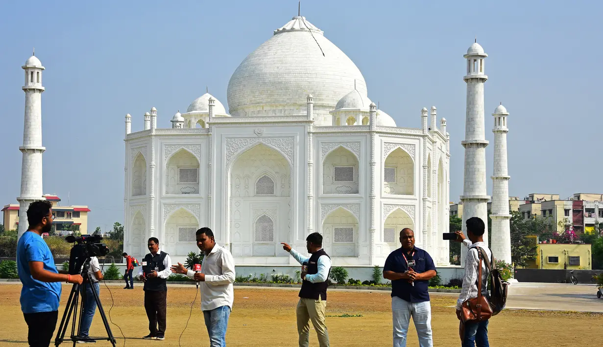 Dalam foto pada 25 November 2021, awak media berdiri di depan replika Taj Mahal di Burhanpur di negara bagian Madhya Pradesh, India. Pengusaha India Anand Prakash Chouksey membangun replika Taj Mahal untuk istrinya dengan biaya hingga sekitar Rp 2,6 miliar. (Uma Shankar MISHRA / AFP)