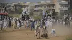 Seorang petani kehilangan kendali atas sapi yang diadunya saat penonton menyaksikan kompetisi balapan sapi tradisional di pinggiran Islamabad, Pakistan, Minggu (27/6/2021). Ditengah pandemi covid-19, balapan sapi ini disaksikan banyak penonton. (Farooq NAEEM/AFP)