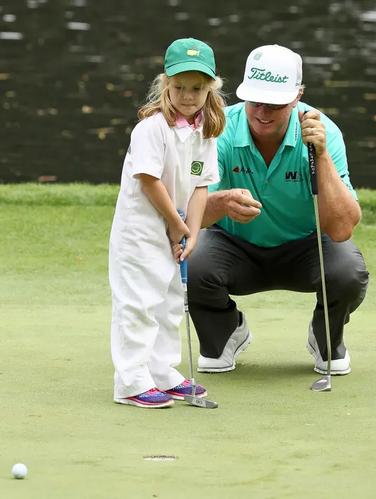 Pegolf Amerika Serikat, Charley Hoffman melihat putrinya, Katelyn memukul bola ketika hari terakhir mengikuti latihan untuk turnamen golf Masters 2018 di Augusta, Georgia, Rabu (4/4). (JAMIE Squire / Getty Images / AFP)