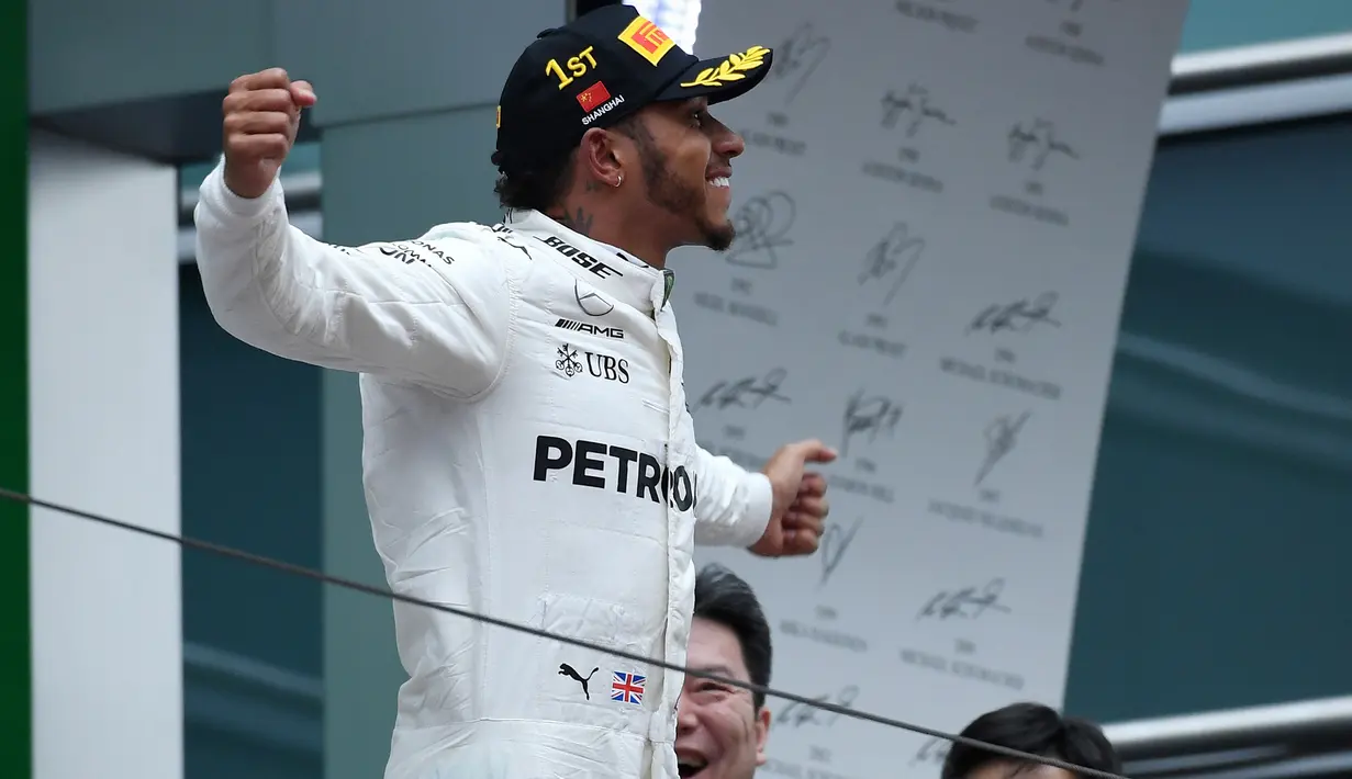 Pembalap Mercedes Lewis Hamilton merayakan kemenangan setelah berhasil memenangi balapan GP China di Sirkuit Internasional Shanghai, Minggu (9/4). Lewis Hamilton jadi pemenang di GP China, dengan Sebastian Vettel di posisi runner-up. (WANG Zhao/AFP)