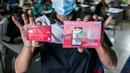 Warga menunjukkan buku tabungan dan ATM usai mengambil Bantuan Sosial Tunai (BST) di SMAN 111, Jakarta, Selasa (19/1/2021). Pemprov DKI Jakarta menyalurkan BST sebesar Rp 300 ribu kepada 1.055.216 KK mulai Januari hingga April 2021. (Liputan6.com/Faizal Fanani)