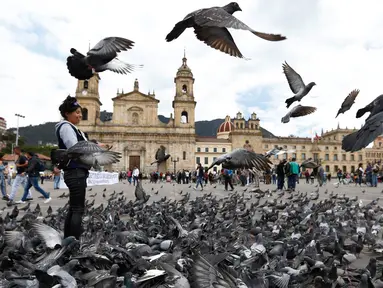 Kawanan burung merpati memenuhi Alun-Alun Bolivar di Bogota, Kolombia, 2 Oktober 2018. Pemerintah Bogota berusaha mengurangi jumlah populasi merpati melalui larangan bagi pengunjung untuk tidak memberi makan lagi burung-burung itu. (AP/Fernando Vergara)