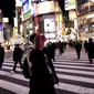 Orang-orang yang memakai masker berjalan di distrik Shibuya di Tokyo (19/1/2022). Pemerintah Jepang menyetujui pembatasan virus corona baru di sebagian besar negara, termasuk ibu kota untuk memerangi rekor infeksi yang dipicu oleh varian Omicron. (AFP/Behrouz Mehri)