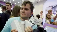 Salah satu pelanggan memegang iPhone 6 yang baru dirilis di sejumlah kota besar di Rusia, Jumat, (26/9/2014). (REUTERS/Maxim Shemetov)