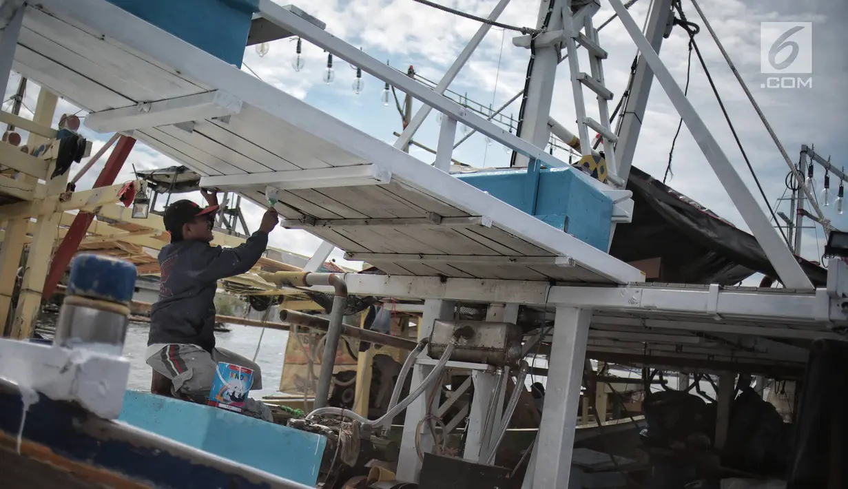 Nelayan mengecat kapal di Pelabuhan Muara Angke, Jakarta, Kamis (27/12). Menurut Suku Dinas KPKP Jakarta Utara siklus angin muson barat merupakan fenomena rutin tahunan yang biasa terjadi. (Liputan6.com/Faizal Fanani)