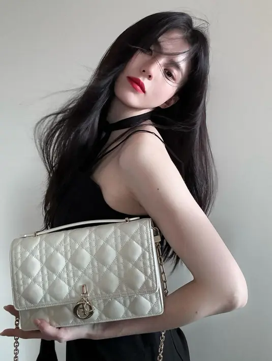 Photoshoot Han So Hee yang memukau. Ia mengenakan dress tanpa lengan berwarna hitam, yang kontras dengan pulasan lipstik merahnya. [Foto: Instagram/xeesoxee]