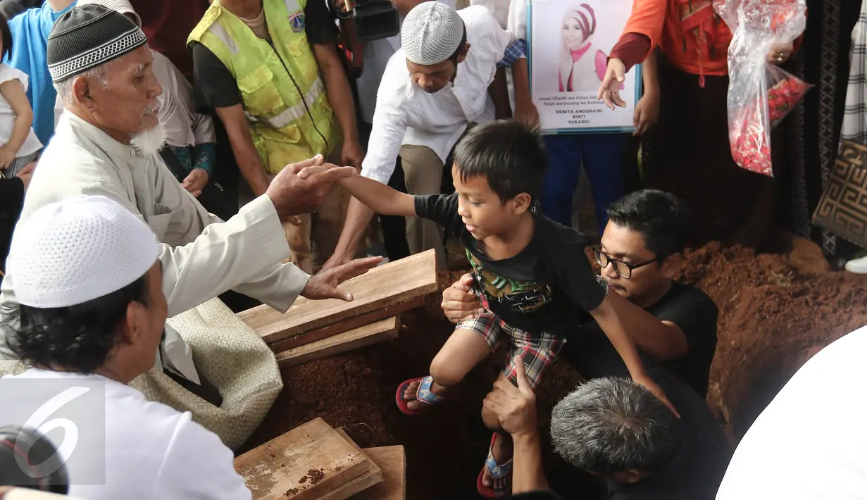 Anak Renita ikut serta dalam proses pemakaman Renita Sukardi di TPU Menteng Pulo, Jakarta, Senin (10/4). Renita berpesan kepada suaminya untuk menjaga anak semata wayangnya tersebut. (Liputan6.com/Herman Zakharia)