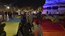 Aktivitas para migran di tenda yang mereka dirikan di Republic square, pusat kota Paris, pada Kamis (25/3/2021). Hampir 400 tenda didirikan di alun-aun tersebut untuk menarik perhatian atas kondisi kehidupan mereka dan menuntut akomodasi. (AP Photo/Rafael Yaghobzadeh)
