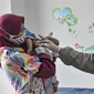Sang ibu mendampingi anaknya saat mengikuti imunisasi di Puskesmas Kecamatan Jatinegara, Jakarta, Kamis (26/11/2020). (merdeka.com/Iqbal S. Nugroho)