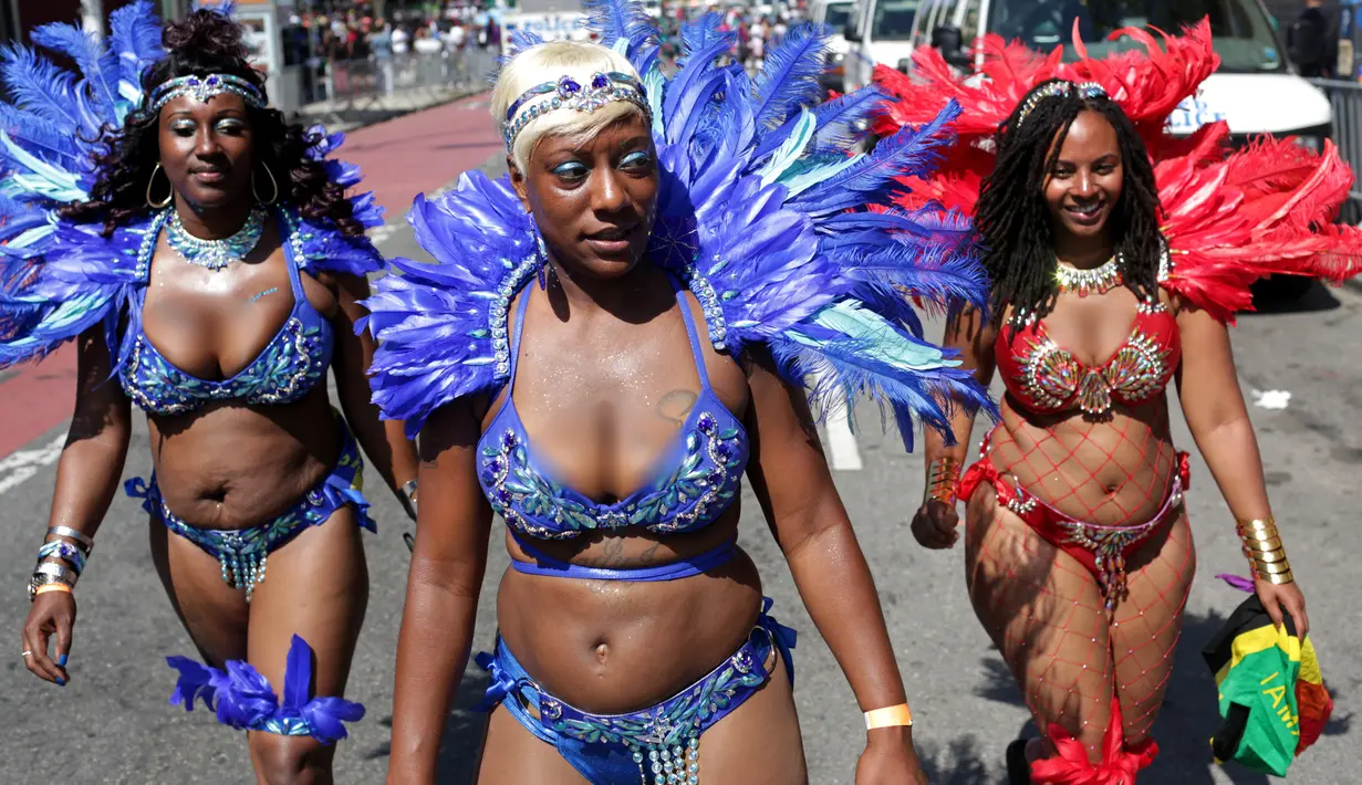 Sejumlah penari berkostum bulu tiba untuk ambil bagian dalam Parade West Indian Day di Brooklyn borough, New York, Senin (4/9). Parade tersebut merupakan salah satu perayaan budaya Karibia terbesar di Amerika Serikat. (Yana Paskova/Getty Images/AFP)