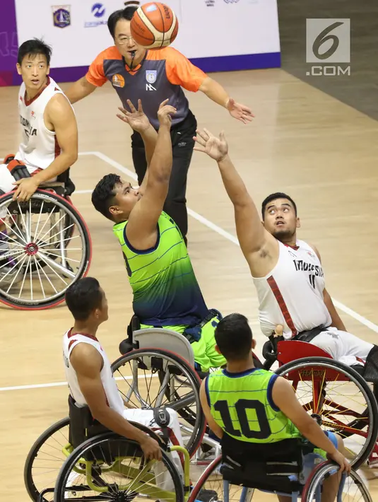 Pebasket difable Indonesia, Kasep Ayatulloh (kanan) mencoba menahan lemparan bola pemain Malaysia, M Hafiz Ramli pada laga Indonesia Para Games Invitational Tournament 2018 di Hall A Senayan, Jakarta, Minggu (1/7). (Liputan6.com/Helmi Fithriansyah)